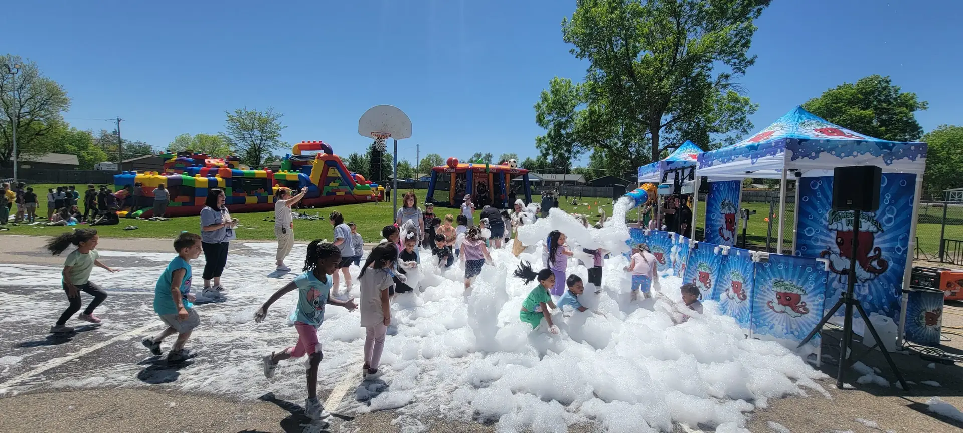 Students enjoying a Foamsational Fun foam party with Bounce N Around inflatables at a Colorado school event