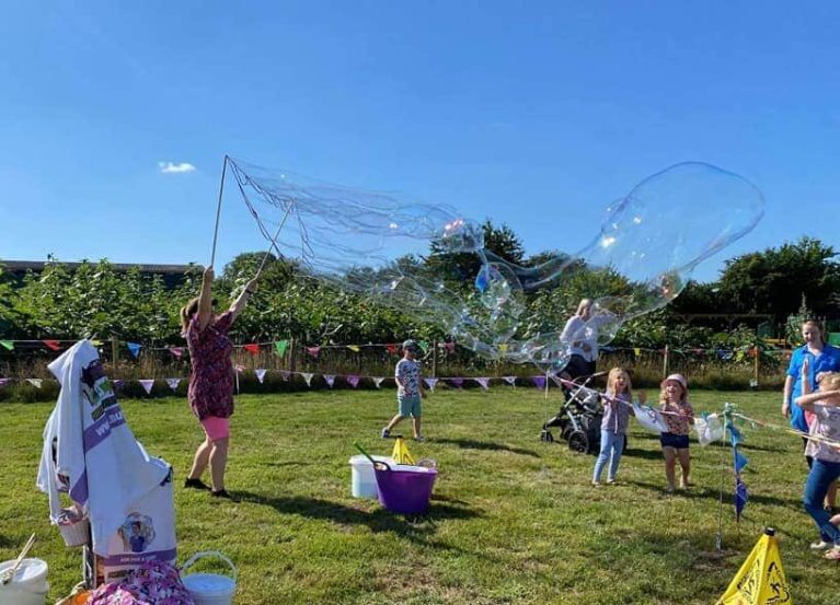 Children enjoying giant bubbles at an outdoor celebration